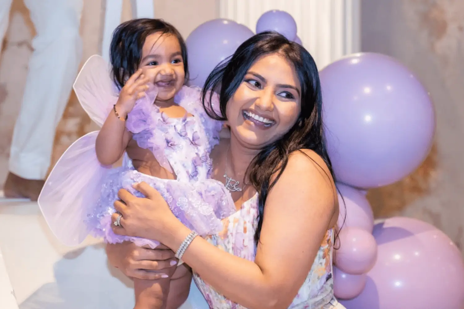 Joyful mother and daughter celebrating with balloons at a magical party.